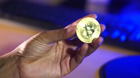 Hand Holding Bitcoin Cryptocurrency Coin with Blue Technology Background Stock Footage 335687075