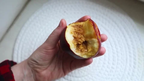 A hand holding a bitten rotten red apple showing internal browning, monilinia fu Stock Footage 343126315