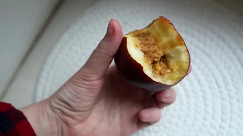 A hand holding a bitten rotten red apple showing internal browning, monilinia fu Stock Footage 343126337