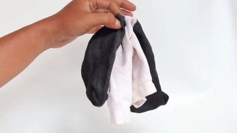 Hand holding a black and white socks isolated Stock Footage 336944480