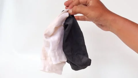 Hand holding a black and white socks isolated Stock Footage 336944484