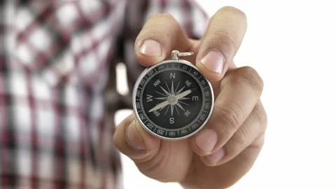 Hand holding the black compass on white background. Stock Footage 230090901