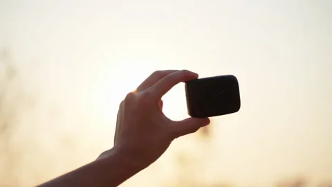 Hand holding black cube sunset 50fps Stock Footage 156231061