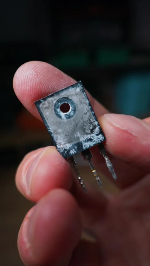 Hand Holding a Black Power Transistor for Electronics Maintenance and Repair Stock Footage 339365097