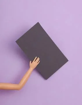 Hand holding a black rectangle on purple background Stock Photos
