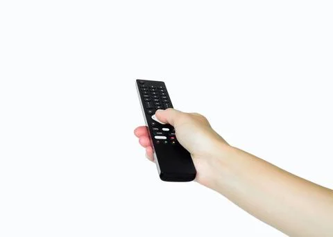 Hand holding a black remote control and pressing a button Fotos de archivo