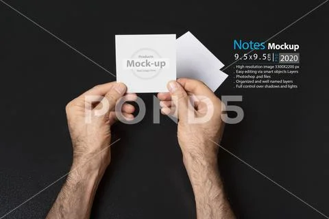 Hand holding a blank note paper or image frame on dark background mock-up ser PSD-sjabloon