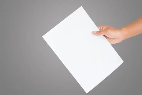 Hand holding blank sheet of white paper isolated on gray 库存照片