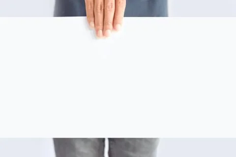 Hand holding blank sheet of white paper isolated on gray Stock Photos