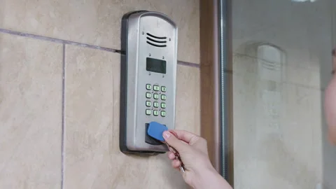 Hand holding blue access card approaches electronic keypad for entry Stock Footage 340901339
