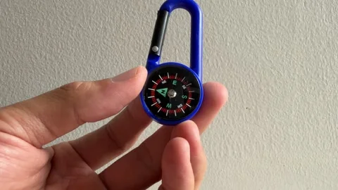Hand holding blue compass hanging keyring. Stock Footage 312091002