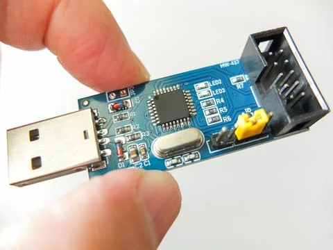 Hand holding a blue electronic PCB board with USB interface and IDC connector Stock Photos