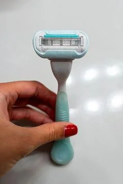Hand holding a blue multi-blade plastic razor Stock Photos