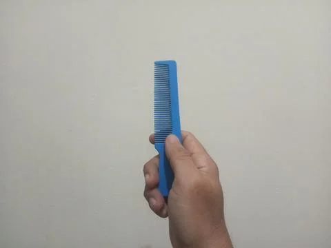 Hand Holding Blue Plastic Comb Stock Photos