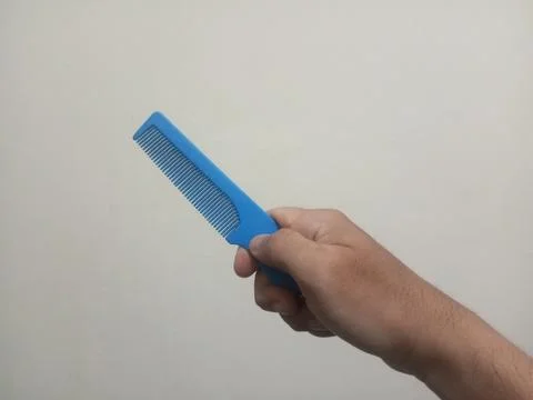 Hand Holding Blue Plastic Comb Stock Photos