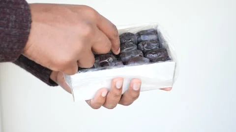 Hand Holding Box of Fresh Delicious Dates on White Background Stock Footage 293660089