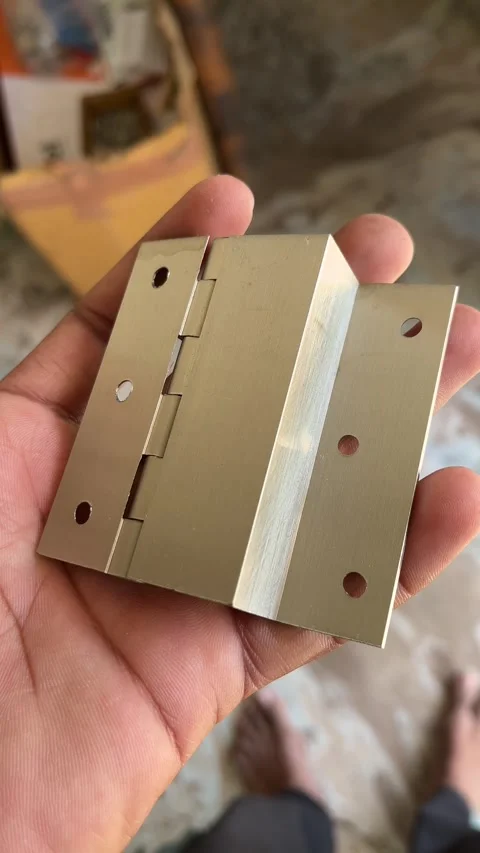 Hand Holding Brass L Hinges with Satin Stainless-Finish Close-Up 動画素材 324609429