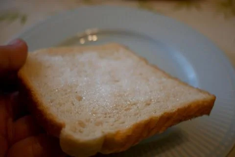 Hand holding bread with sugar cheap food concept Photos