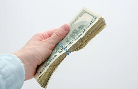 A hand holding a bundle of cash Stock Photos
