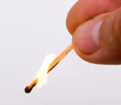 Hand holding a burning match Stock Photos