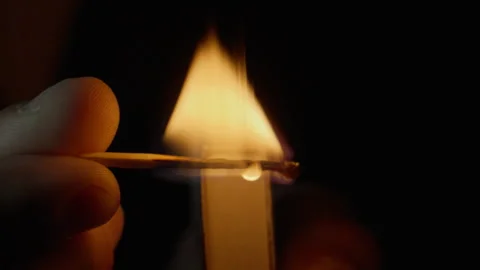 Hand holding burning match puts out flame on black isolated background closeup Stock Footage 332513233
