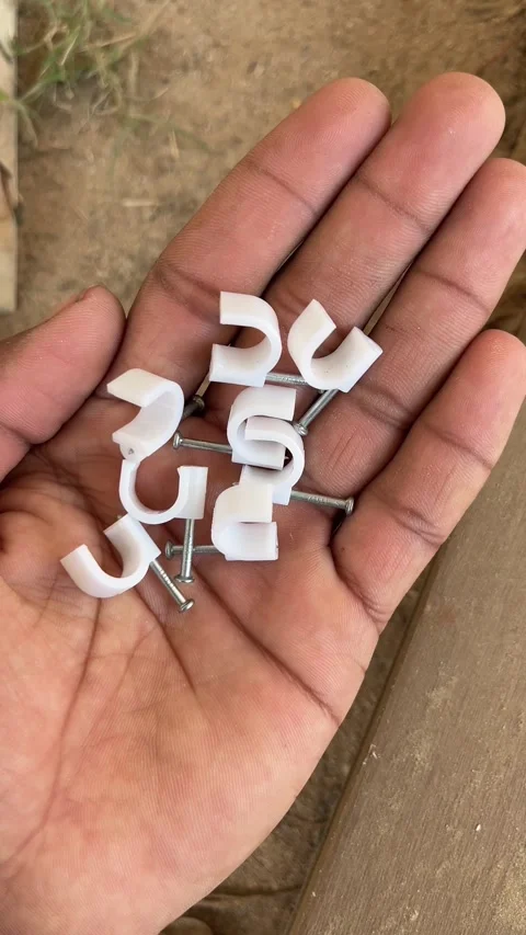 Hand Holding Cable Clips for Electrical Wire Management and Home Installation Stockbeeldmateriaal 324792278