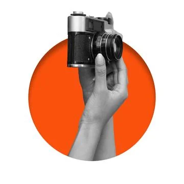Hand holding a camera in front of a circular orange background Stock Photos