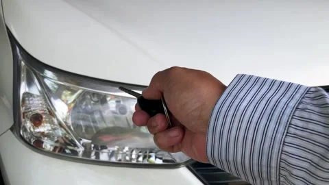 Hand holding car remote key locking or unlocking vehicle Stock Footage 330152816