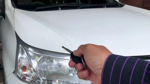 Hand holding car remote key locking or unlocking vehicle Stock Footage 330152827