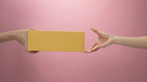 Hand holding cardboard boxes on light pink background. 스톡 동영상 153960352