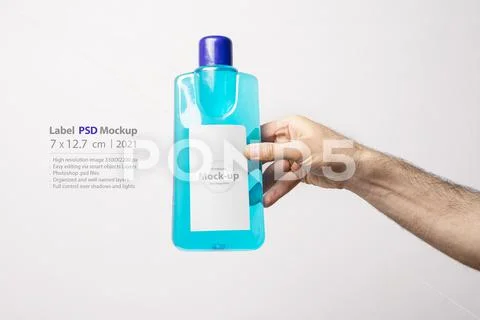 Hand holding a carpet cleaning liquid bottle in front of light gray backgroun PSD Template