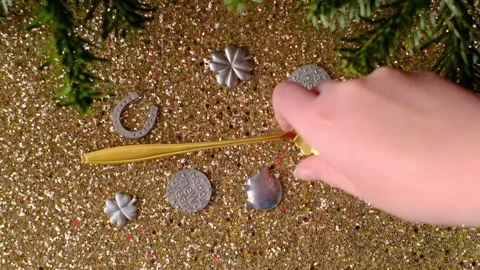Hand holding a casting spoon with a Happy New Year token against golden bokeh Stock-Footage 342074333