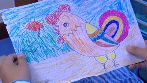Hand holding children's drawing Stock Footage 253772789