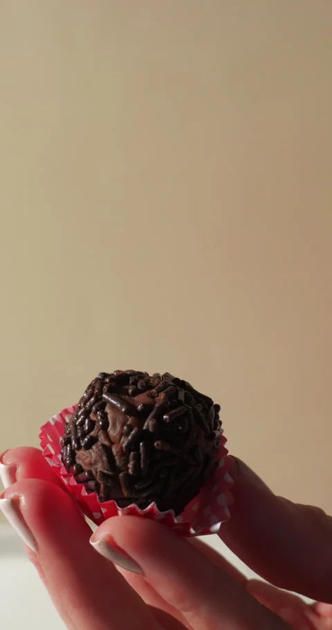 Hand Holding Chocolate Sprinkle Ball in Wrapper Stock Footage 309987505