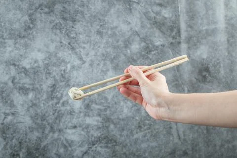 Hand holding a chopstick with a dumpling Stock Photos