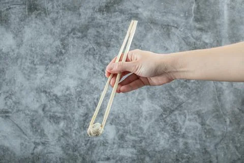 Hand holding a chopstick with a dumpling Stock Photos