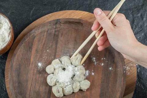 Hand holding a chopstick with a dumpling Stock Photos