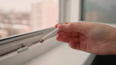 Hand holding cigarette over windowsill white office worker discarding ember, ash Stock Footage 342335361
