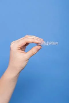 Hand holding clear aligner for teeth straightening treatment Stock Photos