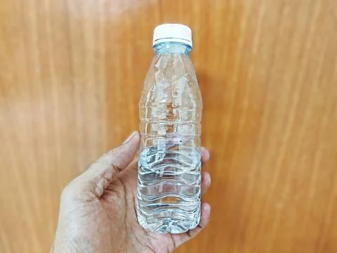 Hand Holding Clear Plastic Drinking Water Bottle Stock Photos
