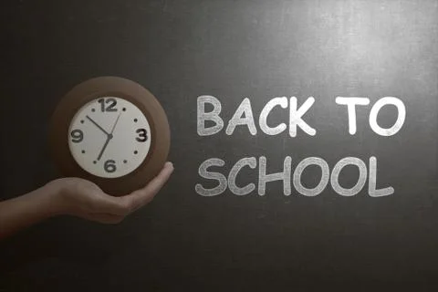 Hand holding the clock with back to school text Stock Photos