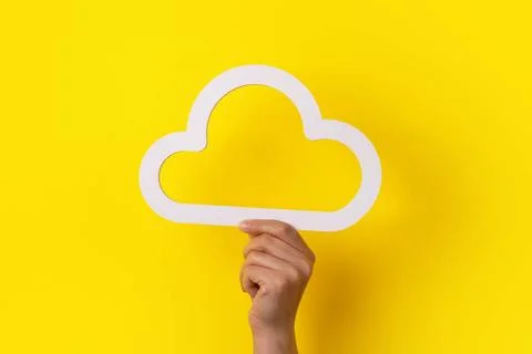 Hand holding cloud Cloud computing concept, hand holding cloud over yellow... Stock Photos