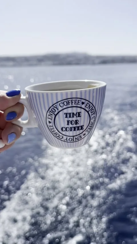 Hand Holding Coffee Cup Against Sparkling Aegean Wake Stock Footage 336964932