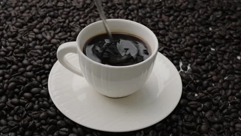 Hand holding coffee stirring spoon in white cup on table. Stock Footage 242829063