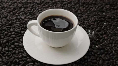 Hand holding coffee stirring spoon in white cup on table. Stock Footage 242829153