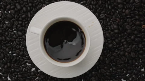 Hand holding coffee stirring spoon in white cup on table. Top view Stock Footage 242829162
