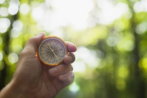 Hand holding compass blurred background Stock Photos