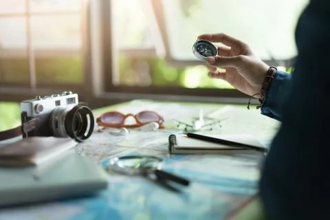 Hand holding compass to plan vacation trip and accessories for travel Stock Photos