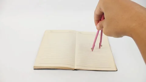 Hand holding compass school drawing on book Stock Footage 325474604