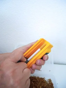 Hand Holding Completed Hand-Rolled Cigarette, Finished DIY Smoking Product 库存照片